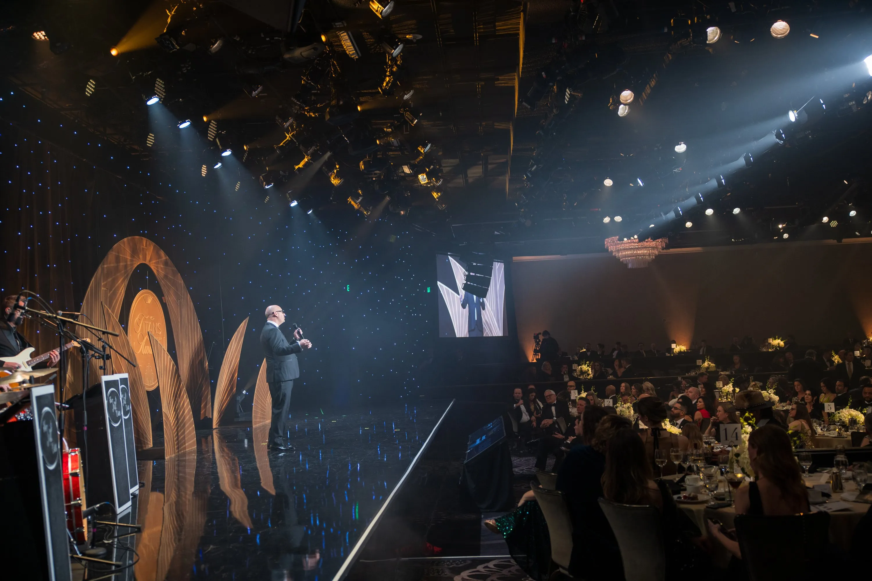 Luis Giraldo performing at the Beverly Hilton, wide stage view with audience and production lighting